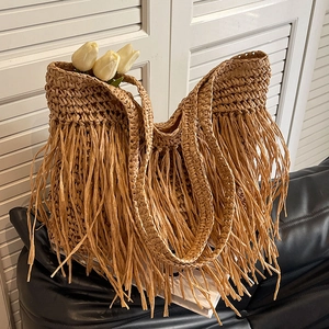 Handwoven straw shoulder bag with long side tassels for beach vacations and summer trips