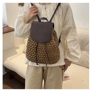 Detail of woven straw backpack with premium brown leather straps and textured cover