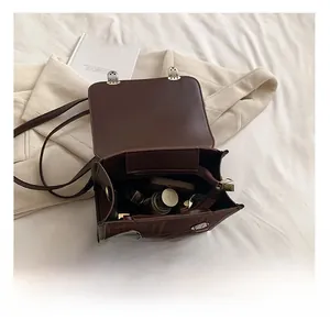 Top view of spacious interior of brown vintage faux leather backpack with makeup items