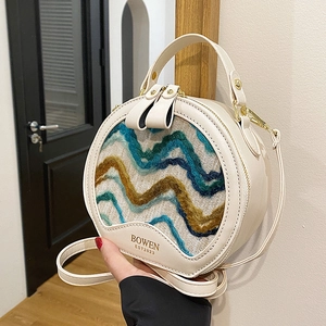 Elegant beige round crossbody bag with colorful woven pattern and detachable shoulder strap
