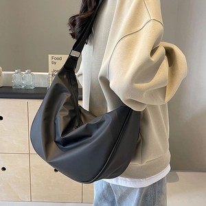 Black Oxford hobo bag shown on a model in a minimalist modern interior setting