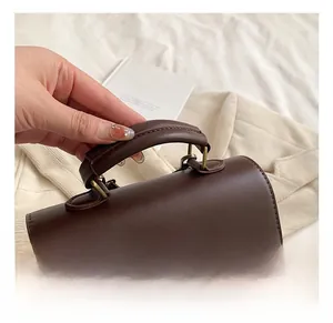 Detail of the vintage dark coffee leather handle and plaid texture with a bronze lock