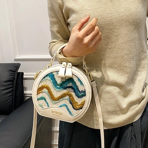 Chic round crossbody bag featuring colorful wave woven texture and elegant cream leather trim