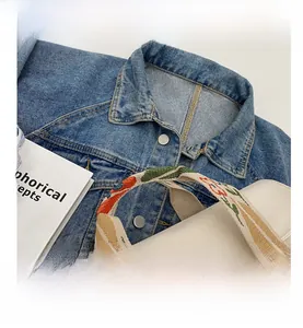 Detail of canvas tote bag wide strap with colorful floral embroidery and soft texture