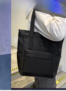 Detailed shot of a black nylon tote bag featuring front zip pocket and side compartments