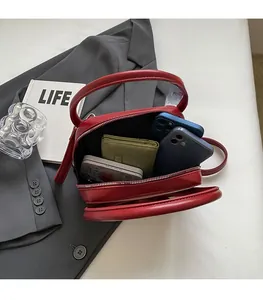 Top view showing spacious interior of red semi-circular handbag with phone and wallet