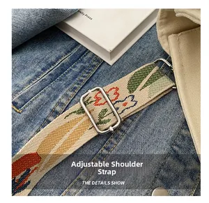 Detail of adjustable floral woven shoulder strap with metal buckle on canvas tote bag