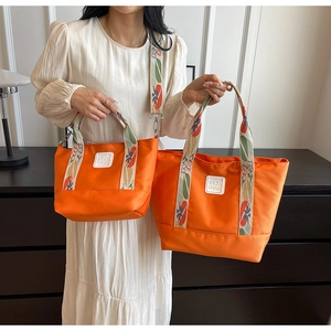 Orange waterproof tote and crossbody bag set with floral patterned jacquard strap