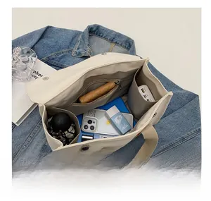 Top view of canvas tote bag interior showing multiple compartments and zipper pocket