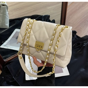 Close-up of off-white lychee leather texture and quilted diamond pattern with gold chain