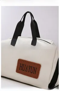 Detail of high-quality Oxford travel bag featuring black webbing handles and a leather logo