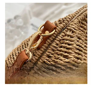 Macro shot of gold alloy hook with brown lychee leather and woven texture details