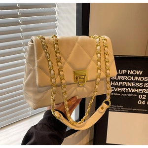 Detail of cream quilted crossbody bag with gold chain and metal twist lock closure
