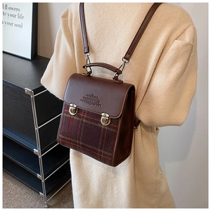 Detail of vintage british style backpack with plaid fabric and brown leather straps