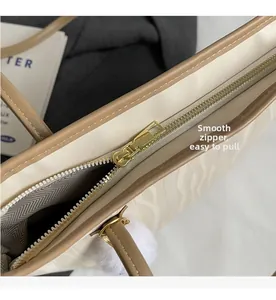 Detail of white wave pattern tote bag with premium gold zipper and brown trim accents