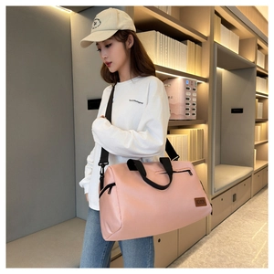 Pink large capacity Oxford travel bag shown worn crossbody with adjustable strap