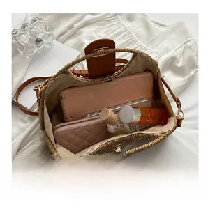 Interior view showing the large capacity of the woven straw bag with leather flap