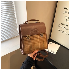 Detail of British vintage plaid backpack with brown faux leather trim and buckle