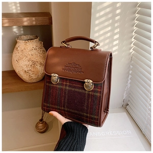 Detail of vintage plaid fabric and leather patchwork with antique brass buckle lock