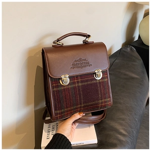 Detail of vintage retro plaid patchwork handbag with metal buckle and top handle