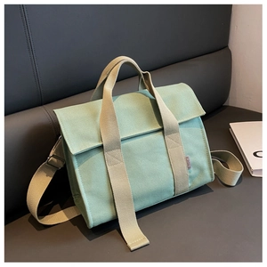 Detail of mint green canvas tote with SJCH woven label and striped reinforced handles