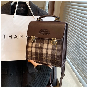 Macro shot of retro brown plaid handbag with vintage bronze clasp and embossed leather flap