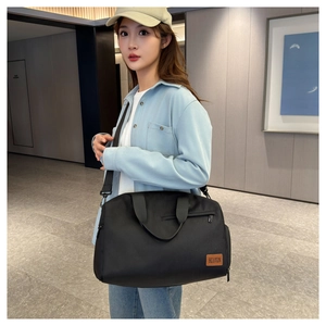 Asian model wearing a large black Oxford fabric travel bag with adjustable strap