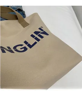 Close-up of beige canvas tote bag showing thick woven texture and NGLIN letter print