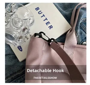 Detail of light pink nylon tote with black detachable hook and reinforced shoulder strap