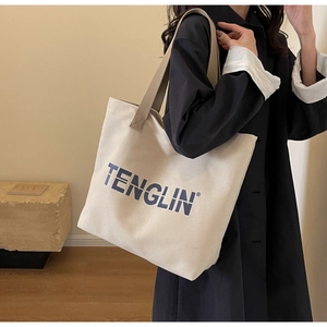 Detailed close-up of a large beige canvas tote bag with blue TENGLIN lettering on the front