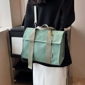 Large mint green canvas tote bag with wide straps shown on a model for daily commute