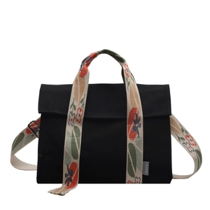 Black canvas tote bag with colorful floral wide strap shown from a frontal view