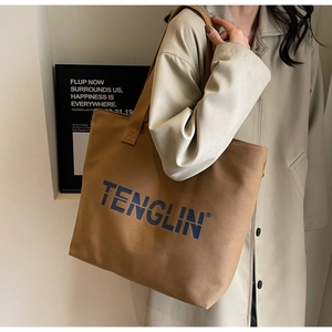 Detailed shoulder view of a large khaki canvas tote bag with TENGLIN branding