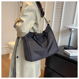 Detailed view of black nylon tote bag with side pocket and versatile shoulder straps