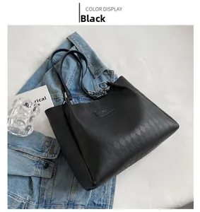 Close-up of black tote bag featuring elegant diamond quilted texture and metal logo plate