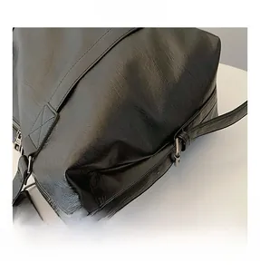 Détail du sac cabas en PU noir plissé montrant les coutures et la bandoulière chaîne