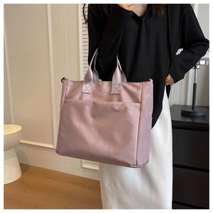 Detail of pink satin nylon tote bag showing spacious side pockets and glossy fabric finish