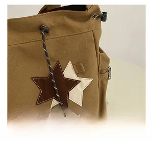 Detailed close-up showing reinforced stitching and star patchwork on canvas tote bag