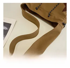 Detail of wide canvas strap and fabric texture on a vintage brown shoulder bag