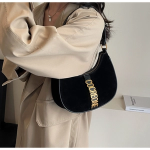 Detail view of black hobo bag in suede and leather with gold COCREONE metal logo