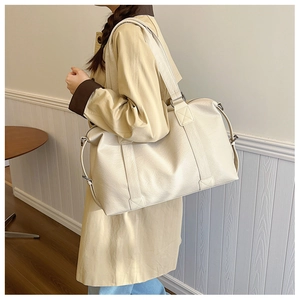 Détail du grand sac de voyage blanc crème en similicuir grainé avec boucle en métal latérale