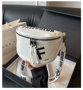 Detailed macro of white textured leather saddle bag with 'FREE COLOR' printed strap