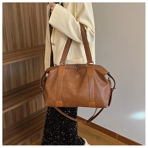 Sac de voyage vintage en similicuir marron avec bandoulière réglable et détails argentés