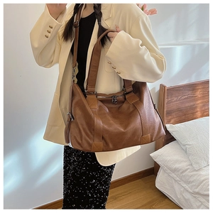 Détails d'un grand sac cabas marron en similicuir avec bandoulière réglable et anses