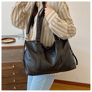 Gros plan d'un sac cabas en similicuir noir avec une bandoulière réglable amovible