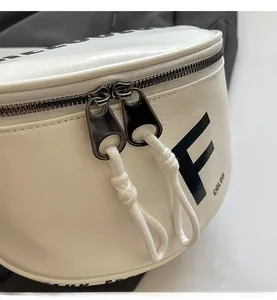 Detail view of smooth metal double zippers and white leather texture on saddle bag