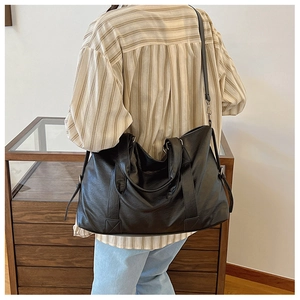 Détail du sac cabas en cuir noir souple avec texture plissée et bandoulière réglable