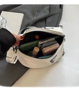 Interior view of large capacity white crossbody bag showing phone, wallet and cosmetics