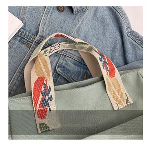 Detailed shot of the canvas tote bag featuring exquisite colorful floral embroidery handles
