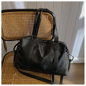 Vue détaillée de la texture du cuir synthétique noir et des coutures du sac cabas